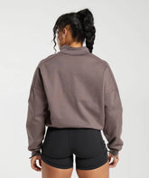المنظر الأمامي لامرأة ترتدي سويت شيرت رمادي اللون Legacy Oversize Sweatshirt من Gymshark | United We Sweat وشورت أس.
